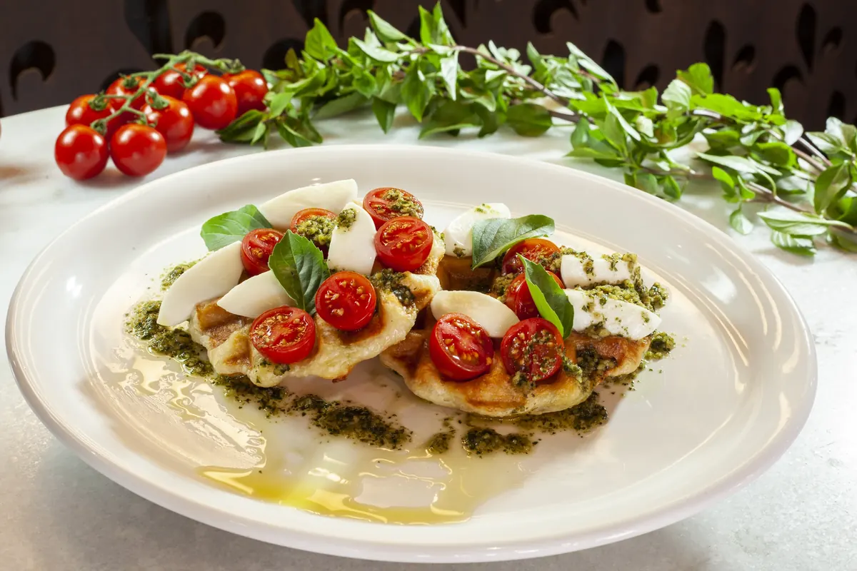 Prato com muçarela de búfala, tomates e molho pesto
